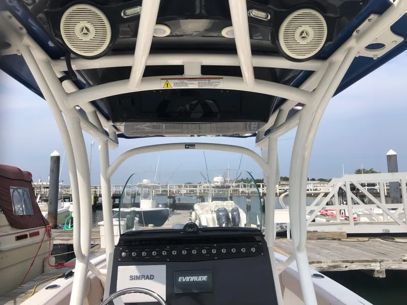 Slide: The Image of 2019 Wellcraft 242 Fisherman boat interior with speakers and navigation equipment at a marina. - 11