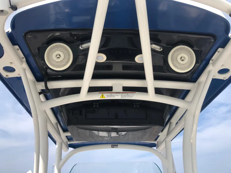 Slide: The Image of 2019 Wellcraft 242 Fisherman boat T-top with speakers and blue sky background. - 12