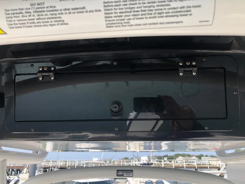Slide: The Image of 2019 Wellcraft 242 Fisherman boat dashboard with storage compartment and safety instructions. - 23