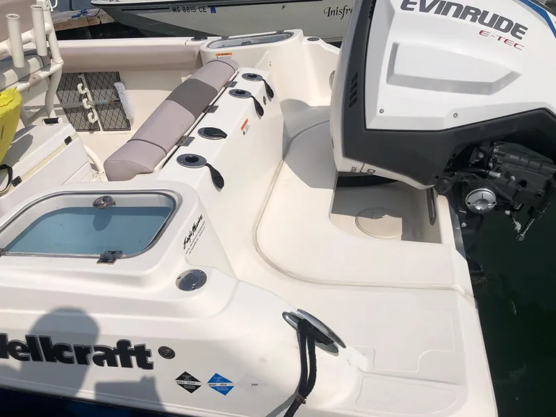Slide: The Image of 2019 Wellcraft 242 Fisherman boat with Evinrude engine, featuring seating and fishing rod holders. - 24