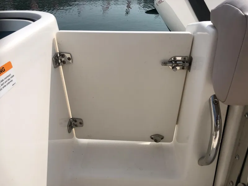 Slide: The Image of 2019 Wellcraft 242 Fisherman boat, open hatch with metal hinges and handle, near water. - 25