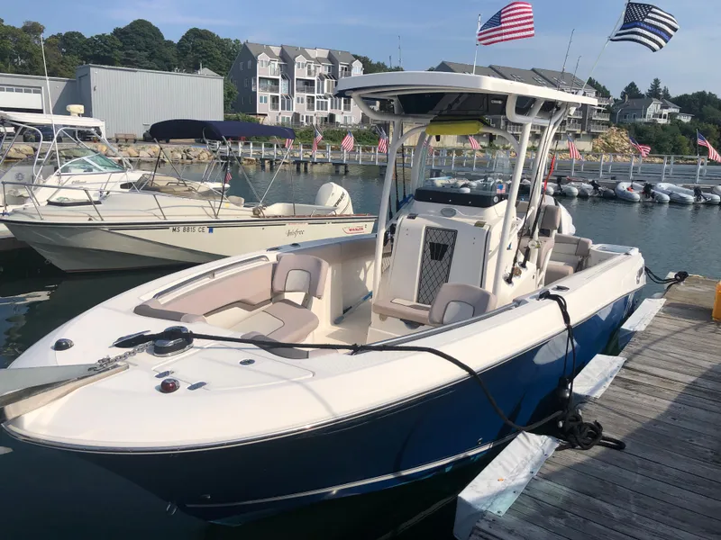 Slide: The Image of 2019 Wellcraft 242 Fisherman boat docked at a marina with American flags. - 3