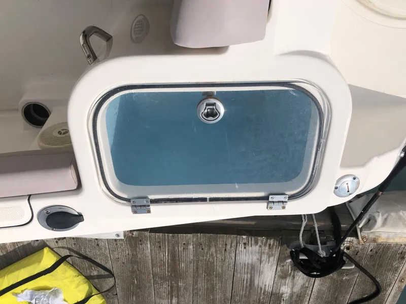 Slide: The Image of 2019 Wellcraft 242 Fisherman livewell with transparent lid on a wooden dock. - 34