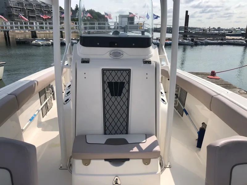 Slide: The Image of 2019 Wellcraft 242 Fisherman boat interior at marina, showcasing seating and console. - 41