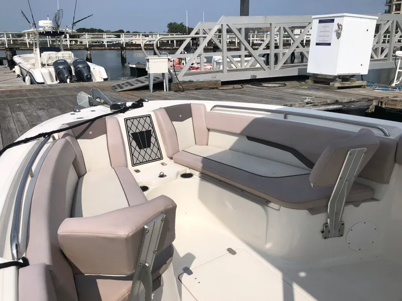 Slide: The Image of 2019 Wellcraft 242 Fisherman boat with spacious seating at a marina dock. - 44