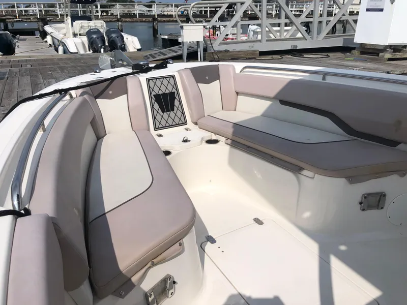 Slide: The Image of 2019 Wellcraft 242 Fisherman boat interior with cushioned seating at a marina. - 45