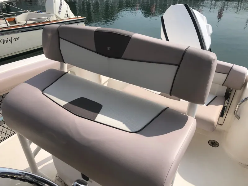 Slide: The Image of 2019 Wellcraft 242 Fisherman boat seat with beige and gray upholstery, docked by calm water. - 8