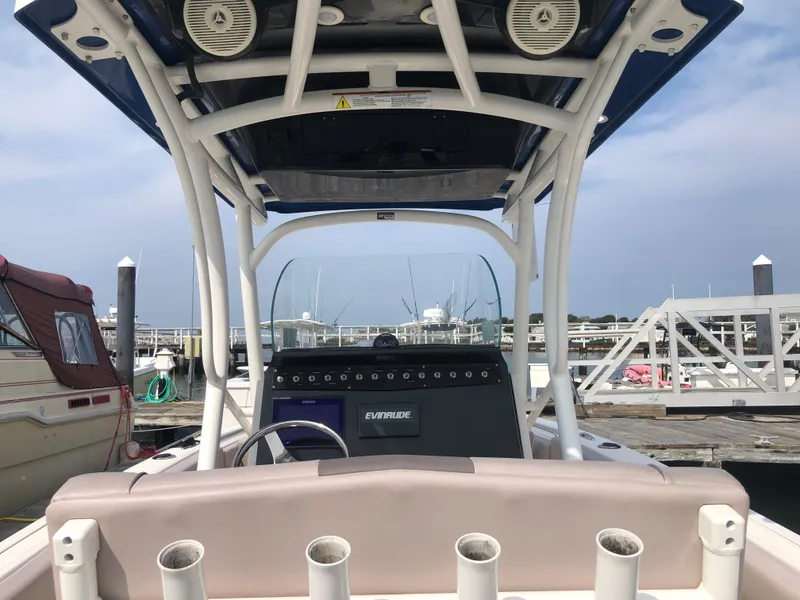 Slide: The Image of 2019 Wellcraft 242 Fisherman boat at marina, featuring console and rod holders. - 9