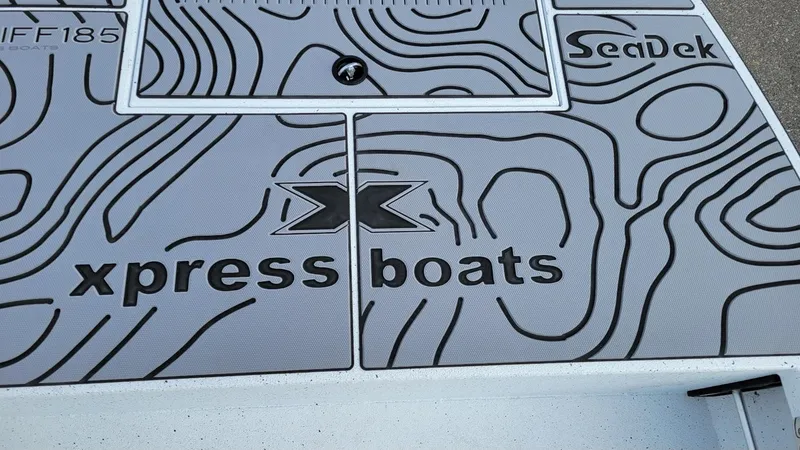 Slide: The Image of 2025 Xpress Skiff 185 boat deck with SeaDek design and branding. - 8