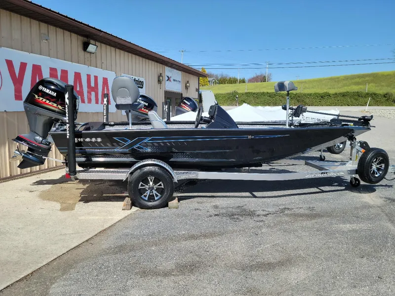 Slide: The Image of 2024 Xpress H18C Crappie Edition boat in stock, displayed outside a Yamaha dealership. - 1