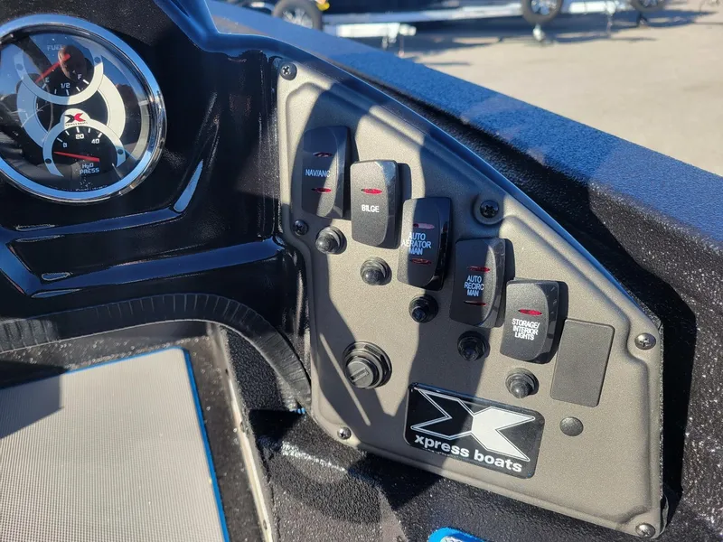 Slide: The Image of 2024 Xpress H18C Crappie Edition boat dashboard with gauges and control switches. - 12