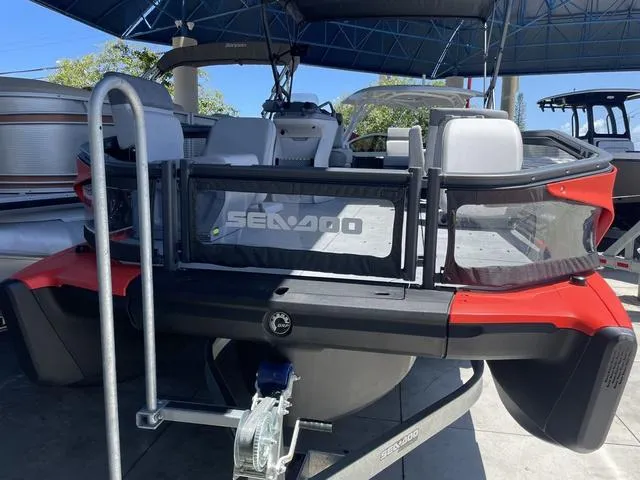 Slide: The Image of 2023 Sea-Doo Switch® Sport 21-230 hp pontoon boat, rear view, docked under a canopy. - 6