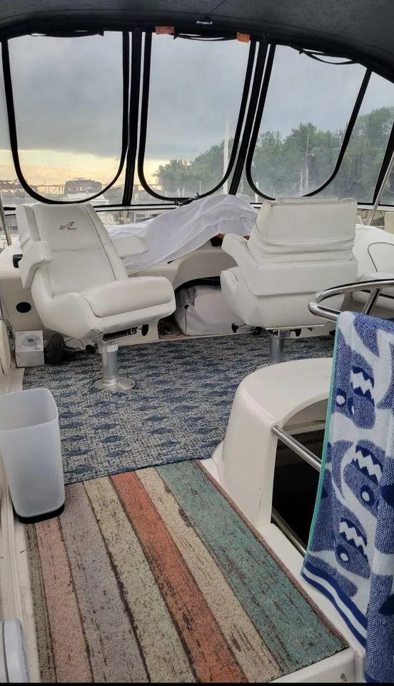 Slide: The Image of 1998 Sea Ray 420 Aft Cabin interior with white seating and colorful rugs. - 14