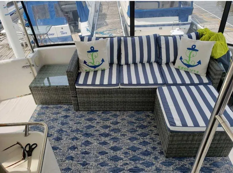 Slide: The Image of 1998 Sea Ray 420 Aft Cabin with striped seating and nautical-themed decor on deck. - 2