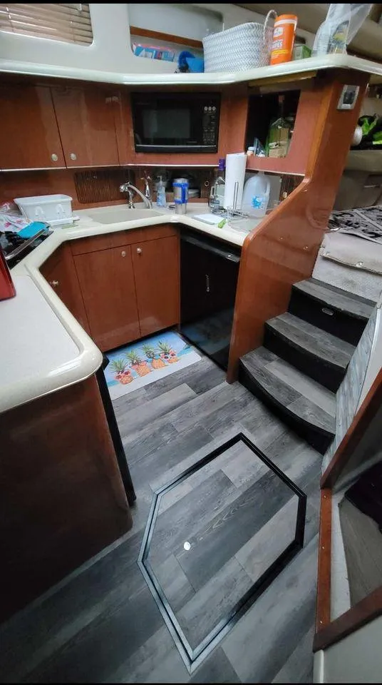 Slide: The Image of 1998 Sea Ray 420 Aft Cabin kitchen with wooden cabinets and modern appliances. - 6