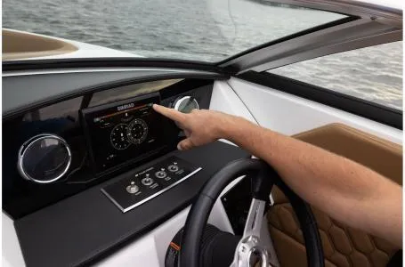 Slide: The Image of Person operating dashboard controls on 2024 Four Winns H1 OB boat. - 26