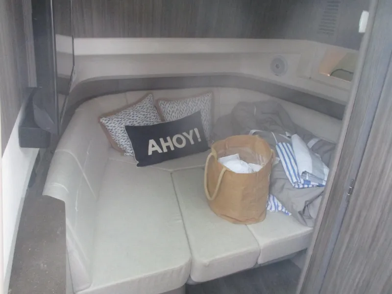 Slide: The Image of Interior cabin of 2021 Sea Ray 400 SLX Outboard with cozy seating and Ahoy! pillow. - 10
