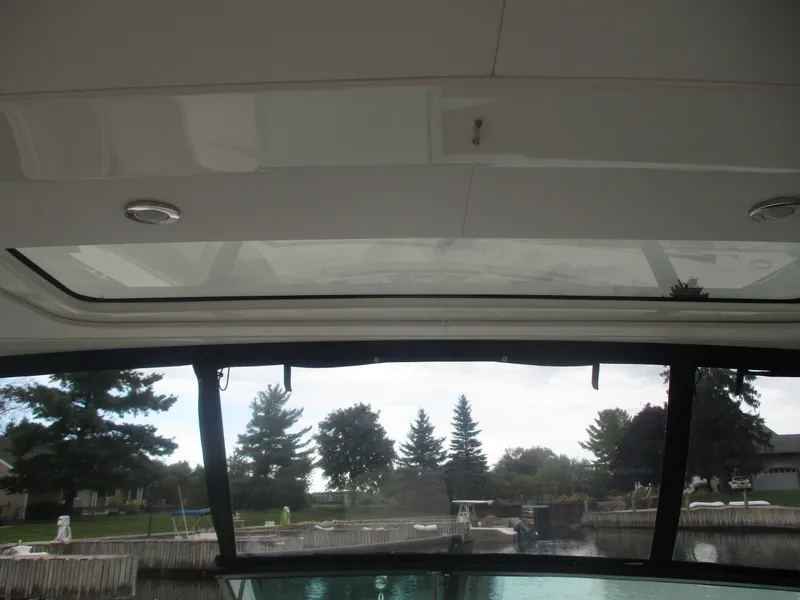 Slide: The Image of Interior view of 2021 Sea Ray 400 SLX Outboard with sunroof and waterfront scenery. - 12