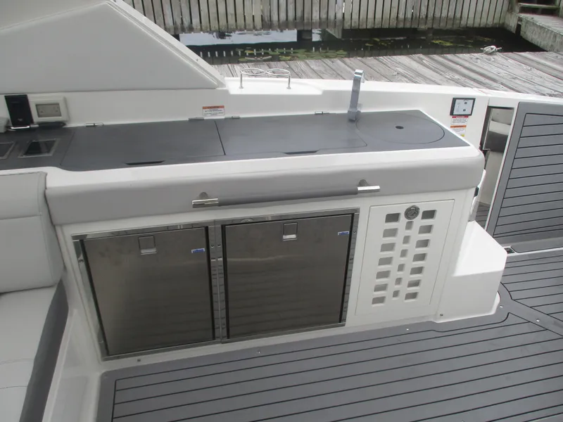 Slide: The Image of 2021 Sea Ray 400 SLX Outboard boat deck with built-in storage and amenities. - 14