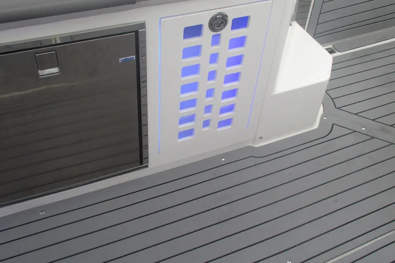 Slide: The Image of Control panel and refrigerator on 2021 Sea Ray 400 SLX Outboard boat. - 16