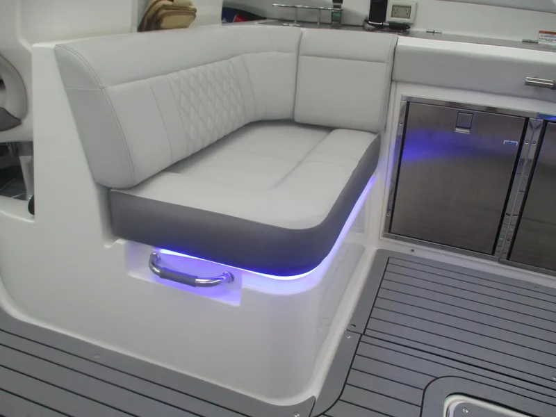 Slide: The Image of 2021 Sea Ray 400 SLX Outboard interior with cushioned seating and ambient lighting - 17