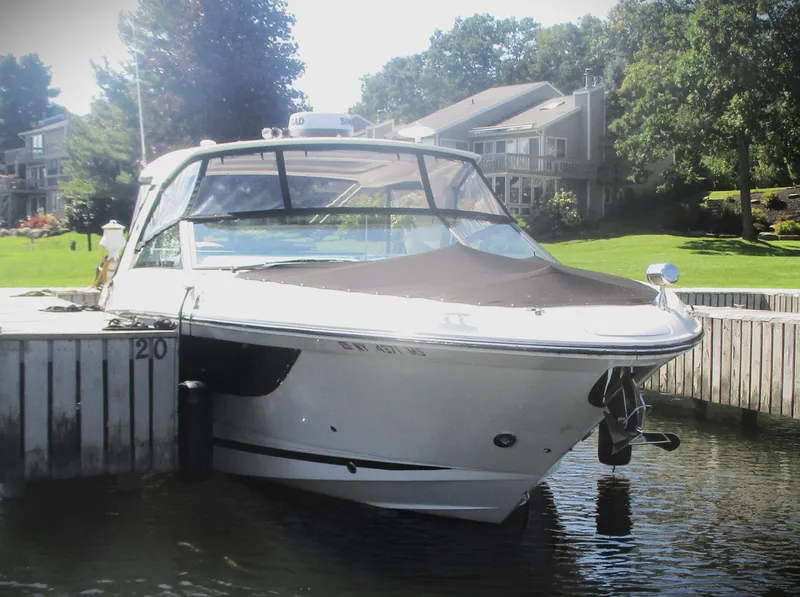 Slide: The Image of 2021 Sea Ray 400 SLX Outboard docked at a lakeside marina. - 21