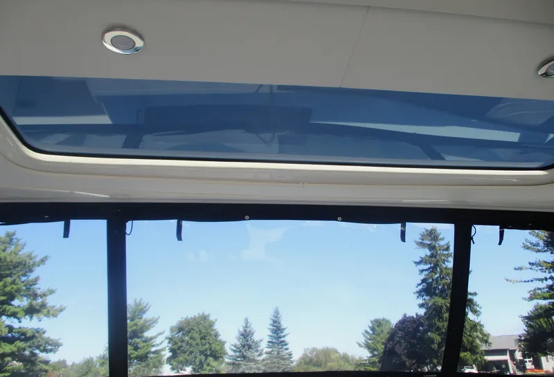 Slide: The Image of Interior view of 2021 Sea Ray 400 SLX Outboard with sunroof and scenic background. - 23