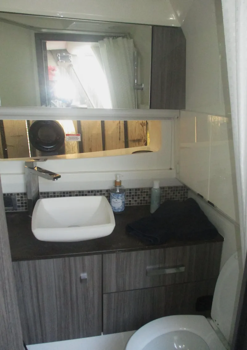 Slide: The Image of Modern bathroom in 2021 Sea Ray 400 SLX Outboard boat with sink and mirror. - 26