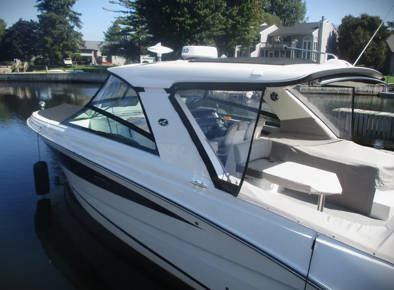 Slide: The Image of 2021 Sea Ray 400 SLX Outboard boat docked in a serene residential marina. - 38