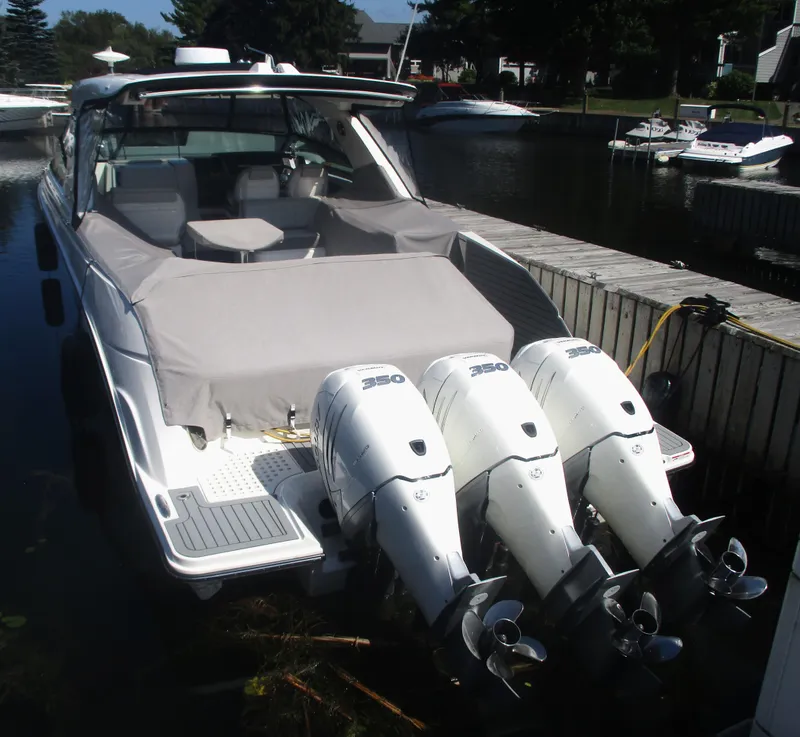 Slide: The Image of 2021 Sea Ray 400 SLX Outboard boat docked with triple outboard engines. - 39