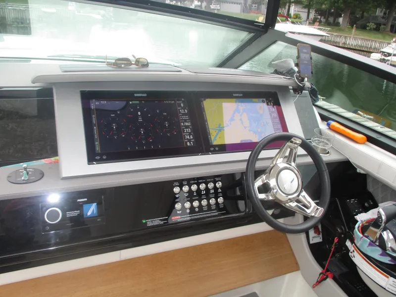 Slide: The Image of 2021 Sea Ray 400 SLX Outboard helm with navigation screens and steering wheel. - 4
