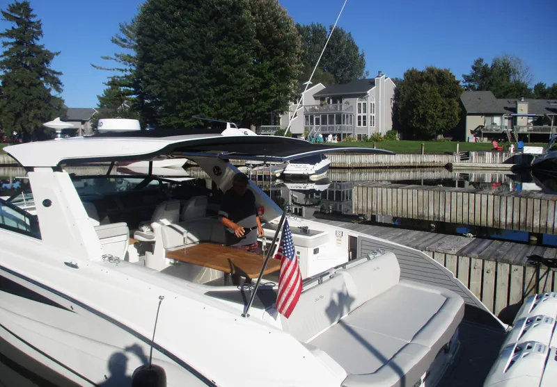 Slide: The Image of 2021 Sea Ray 400 SLX Outboard docked at a marina with a person onboard. - 44