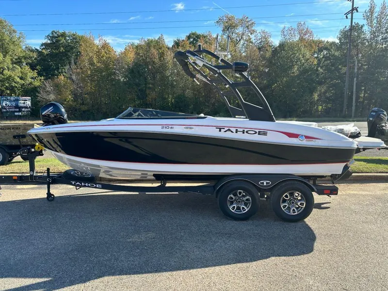 The Image of 2024 Tahoe 210 Si Limited boat on a trailer, parked outdoors. - 0