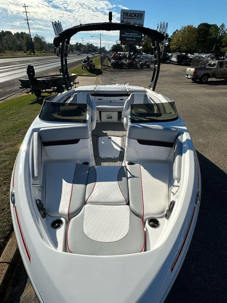 Slide: The Image of 2024 Tahoe 210 Si Limited boat with sleek white and red interior, docked outdoors. - 2