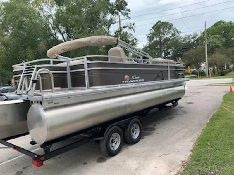 The Image of 2024 Sun Tracker Sportfish 24 XP3 pontoon boat on a trailer. - 1
