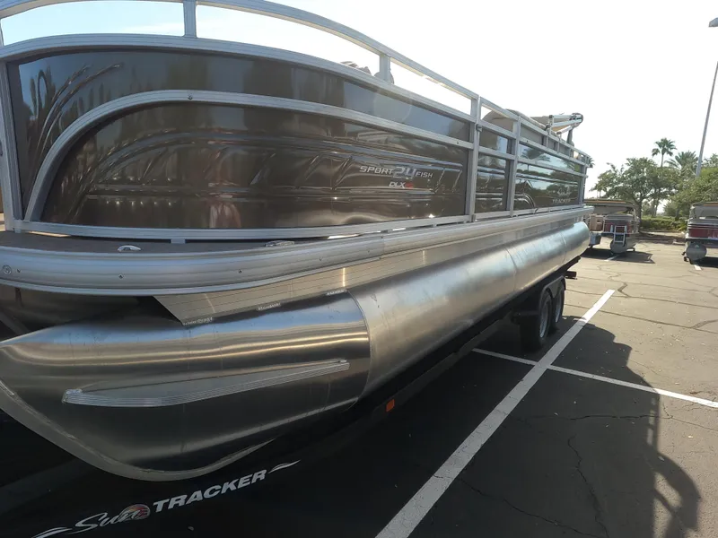 Slide: The Image of 2024 Sun Tracker Sportfish 24 XP3 pontoon boat in a parking lot. - 6