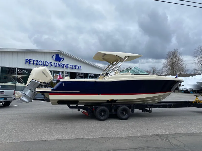 Slide: The Image of 2026 Chris-Craft Calypso 28 boat interior with seating and table in a storage facility. - 3