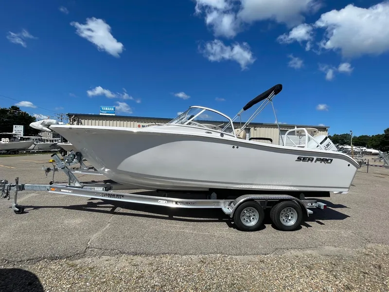 Slide: The Image of 2024 Sea Pro 240 DC Sport boat on a trailer under a clear blue sky. - 0