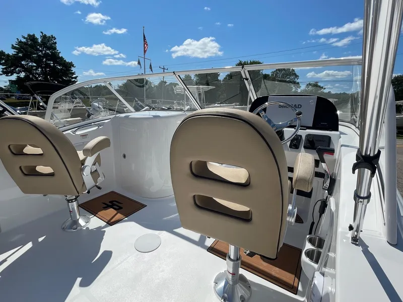 Slide: The Image of 2024 Sea Pro 240 DC Sport boat interior with beige seats and modern dashboard. - 11