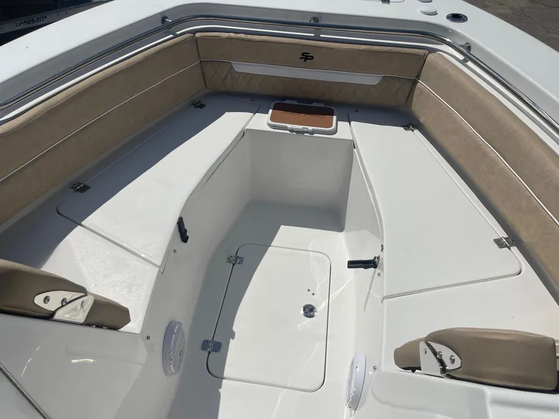 Slide: The Image of 2024 Sea Pro 240 DC Sport boat interior with cushioned seating and storage compartments. - 7