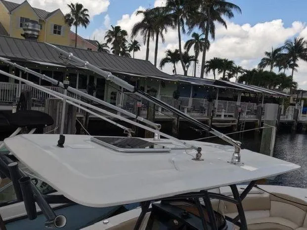 Slide: The Image of 2017 Sea Fox 288 Commander boat roof with fishing rod holders, docked near palm trees. - 13