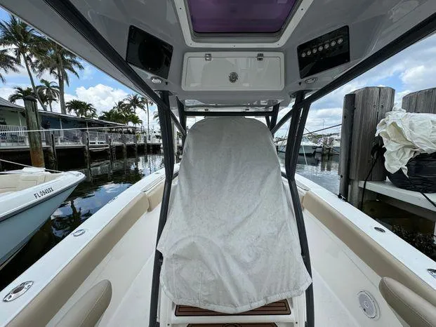 Slide: The Image of 2017 Sea Fox 288 Commander boat interior at dock, covered seat, palm trees in background. - 27
