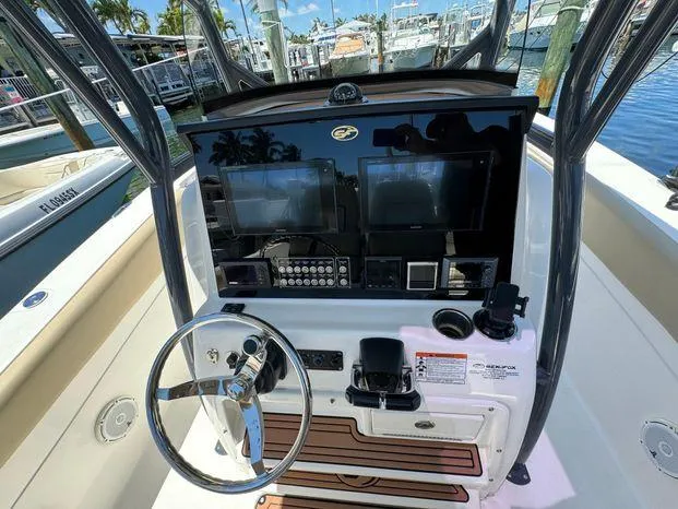 Slide: The Image of 2017 Sea Fox 288 Commander boat dashboard with dual screens and steering wheel at marina. - 42