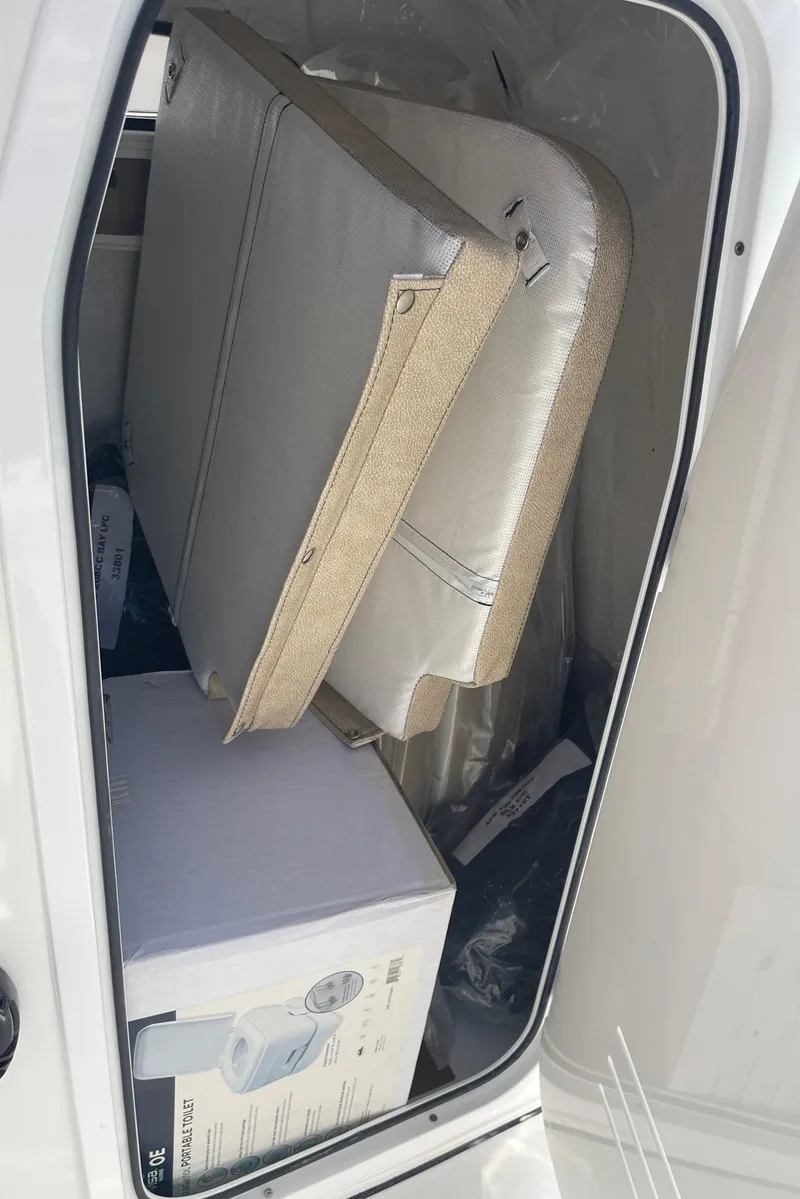 Slide: The Image of 2024 Sea Pro 202 CC storage compartment with cushions and a box. - 7