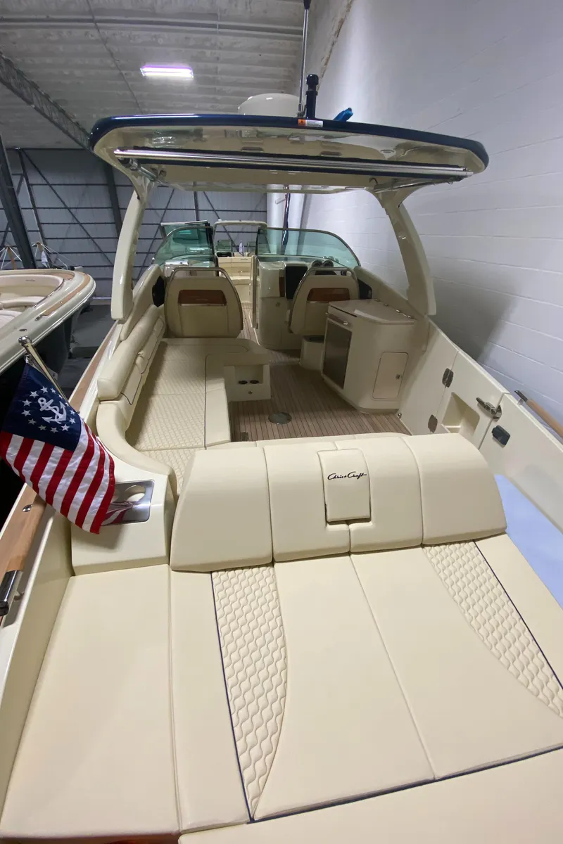 Slide: The Image of 2024 Chris-Craft LAUNCH GT 35 luxury boat interior with beige seating and American flag. - 8