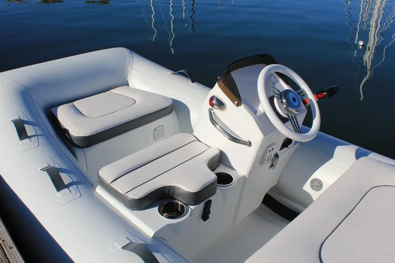 Slide: The Image of 2023 Walker Bay 365 STX Deluxe boat interior with steering wheel and controls. - 8