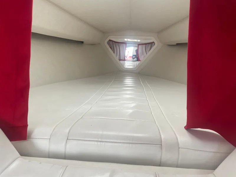 Slide: The Image of Interior cabin of a 1995 Fountain 42 Executioner boat with white upholstery and red curtains. - 17