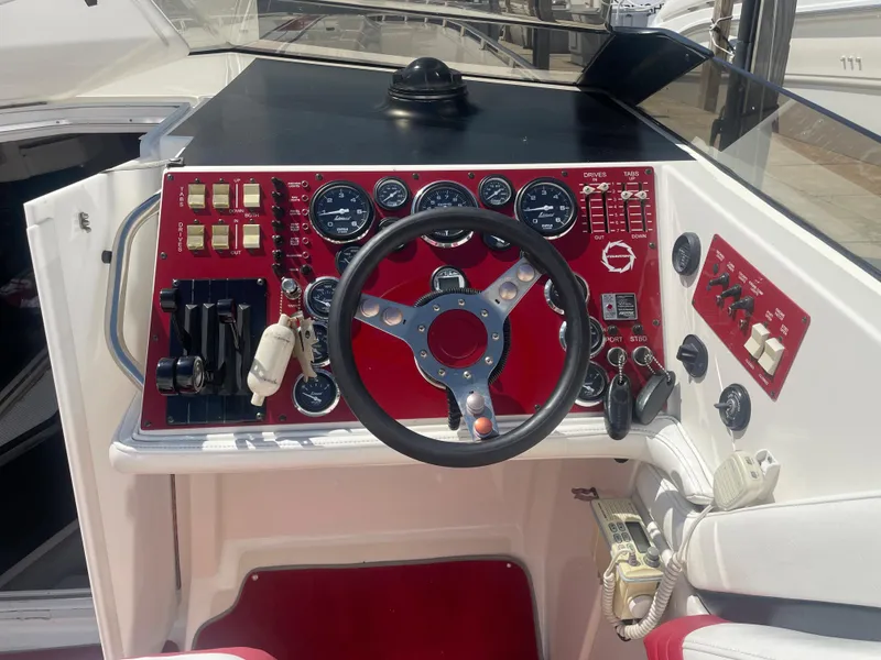 Slide: The Image of 1995 Fountain 42 Executioner boat dashboard with steering wheel and control panel. - 26