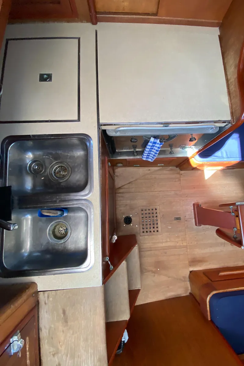 Slide: The Image of Interior of 1962 Hinckley Bermuda 40 sailboat showing kitchen sink and wooden cabinetry. - 9