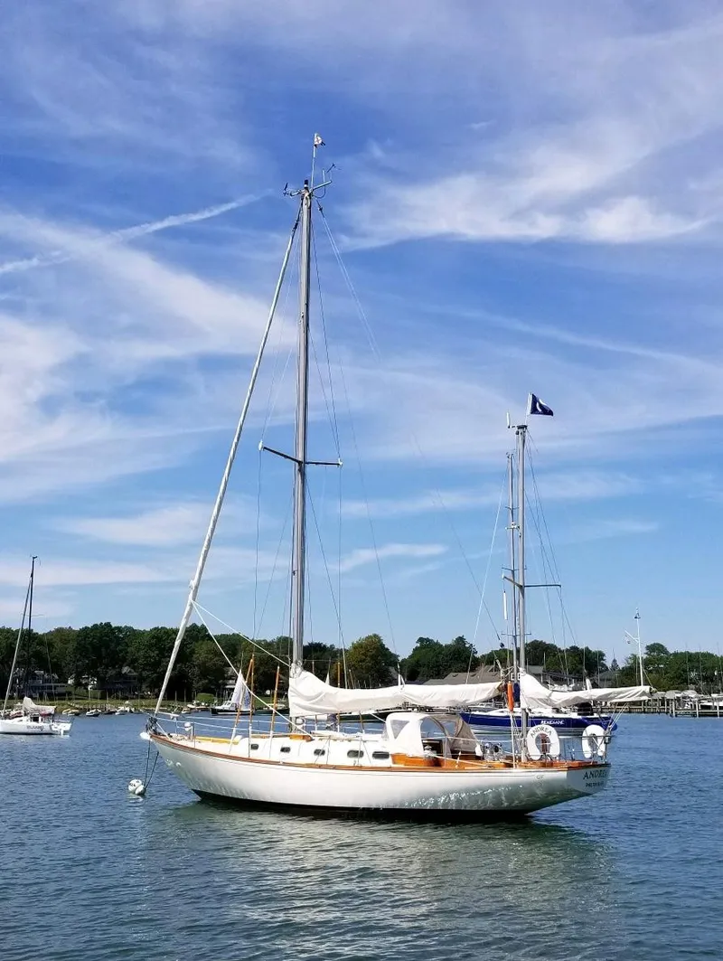 The Image of Hinckley Bermuda 40 sailboat from 1962 on calm water under a blue sky. - 1